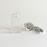 UWO Rostfrei dispenser with the stainless steel top detached beside the glass body