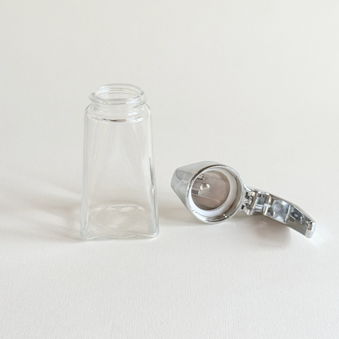 UWO Rostfrei dispenser with the stainless steel top detached beside the glass body