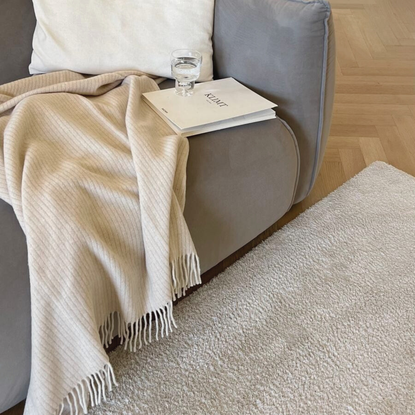 Beige Sustainable Wool and Cashmere Throw made in Italy from recycled cashmere on sofa with glass