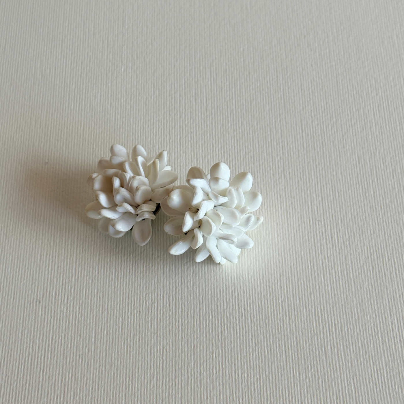 Sculptural white floral clip-on earrings detail
