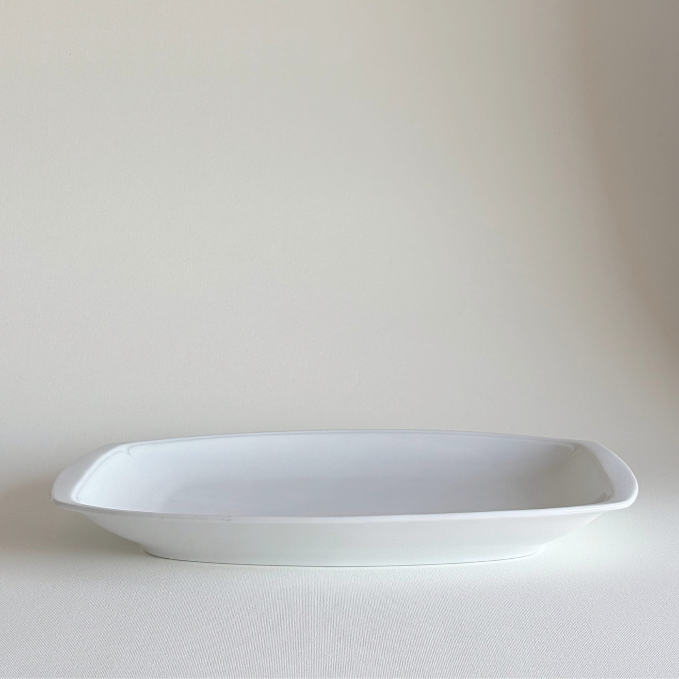 Ceramic Serving Dish in white glazed ceramic with rectangular shape, rounded corners, and a subtle raised leaf-relief border detail.