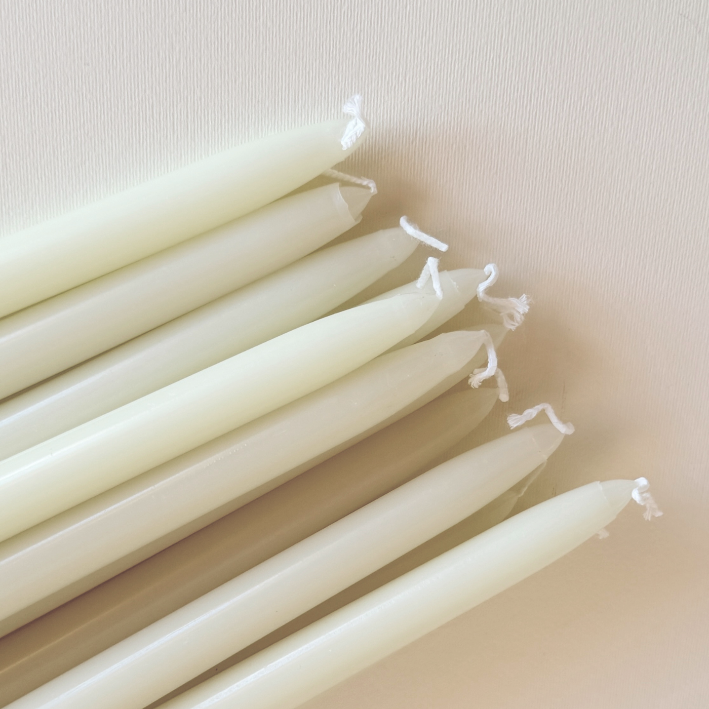 Cereria Graziani Tapered Dinner Candles, a set of ivory wax tapers with smooth surfaces and white wicks.