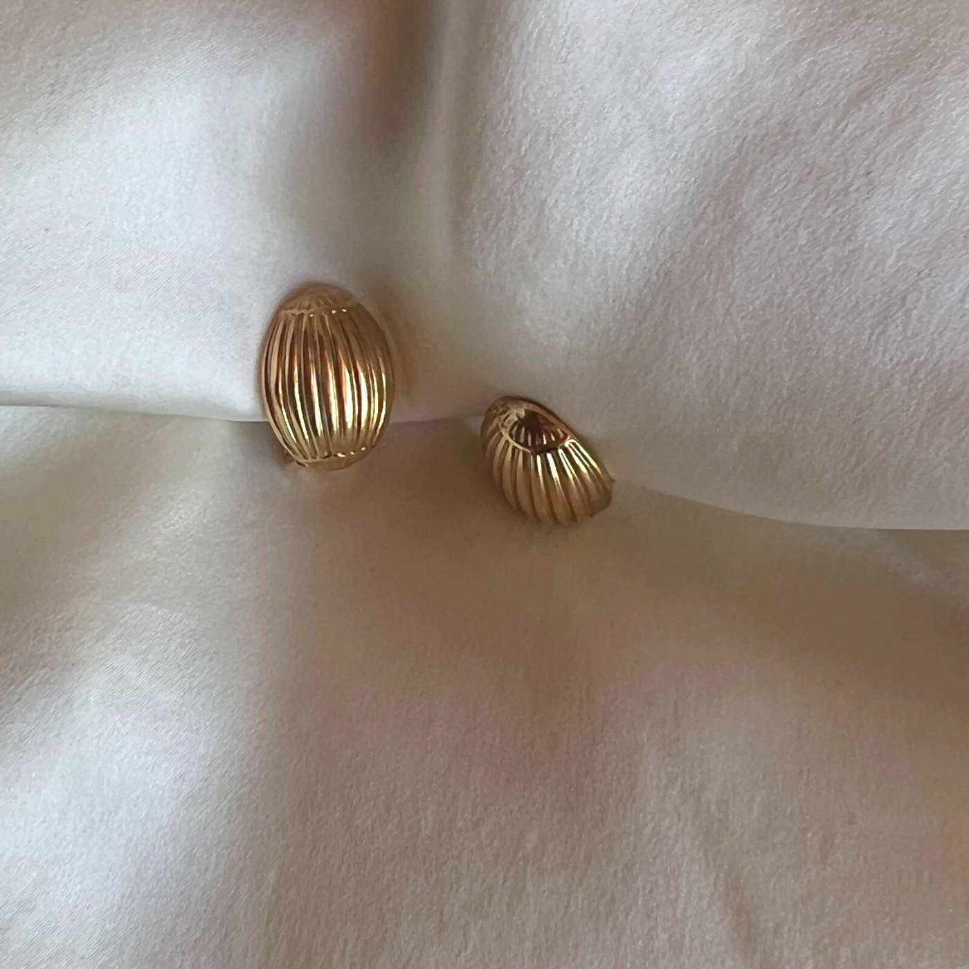 Sculptural golden clip earrings in small oval shape