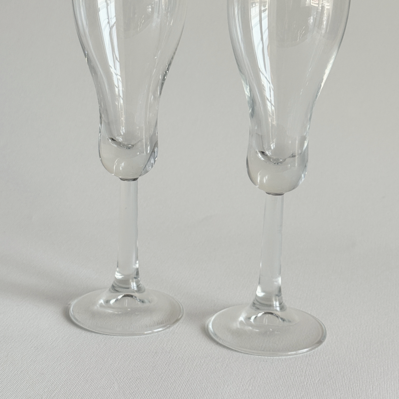 Italian champagne tulip flutes — base view showing rounded foot and overall condition, minor surface marks