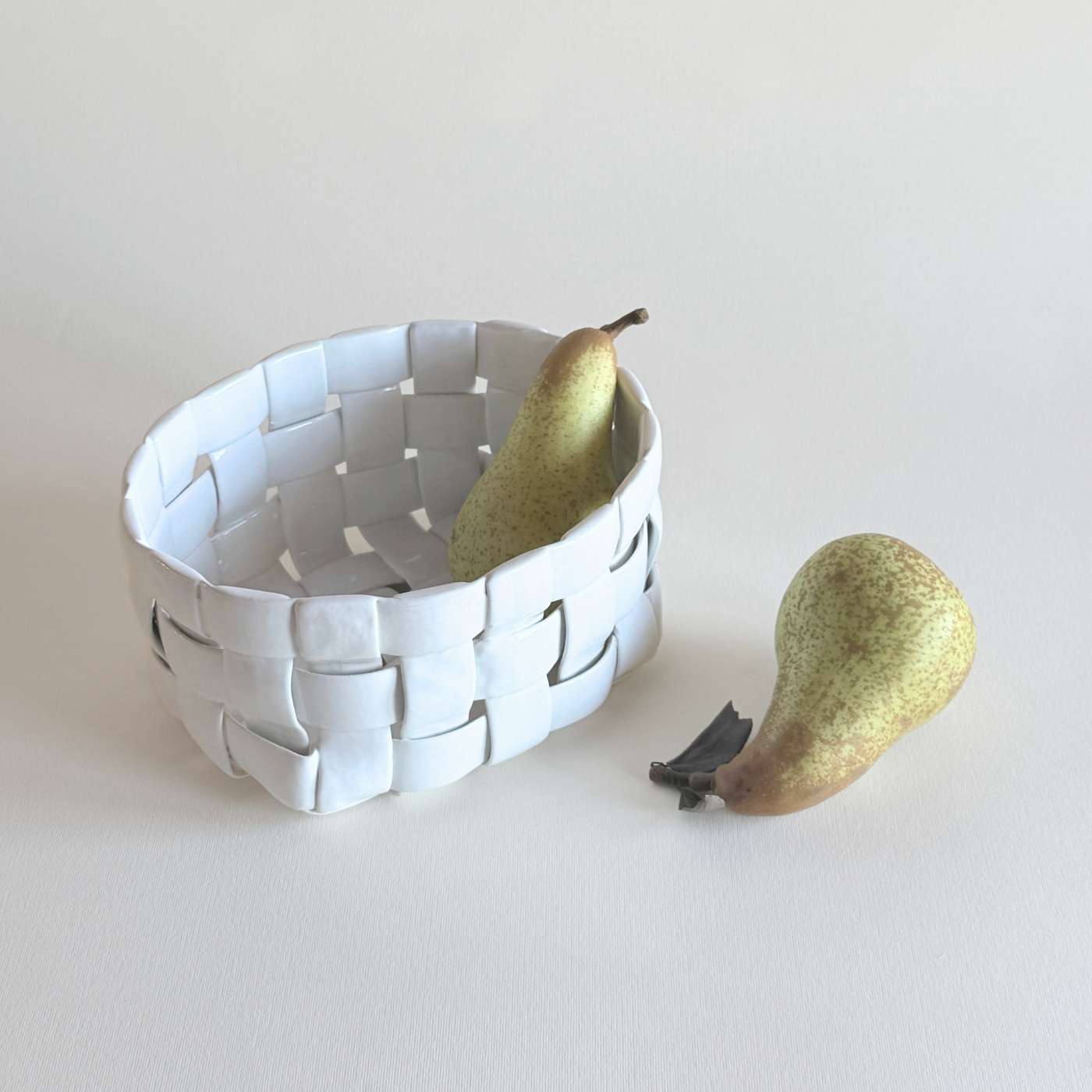 Pierced porcelain basket in white glaze, woven cane-effect lattice