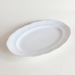 Side profile of white oval porcelain serving dish — low lip, 3 cm height, foot ring base