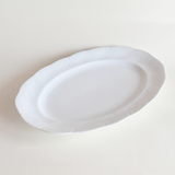 Side profile of white oval porcelain serving dish — low lip, 3 cm height, foot ring base