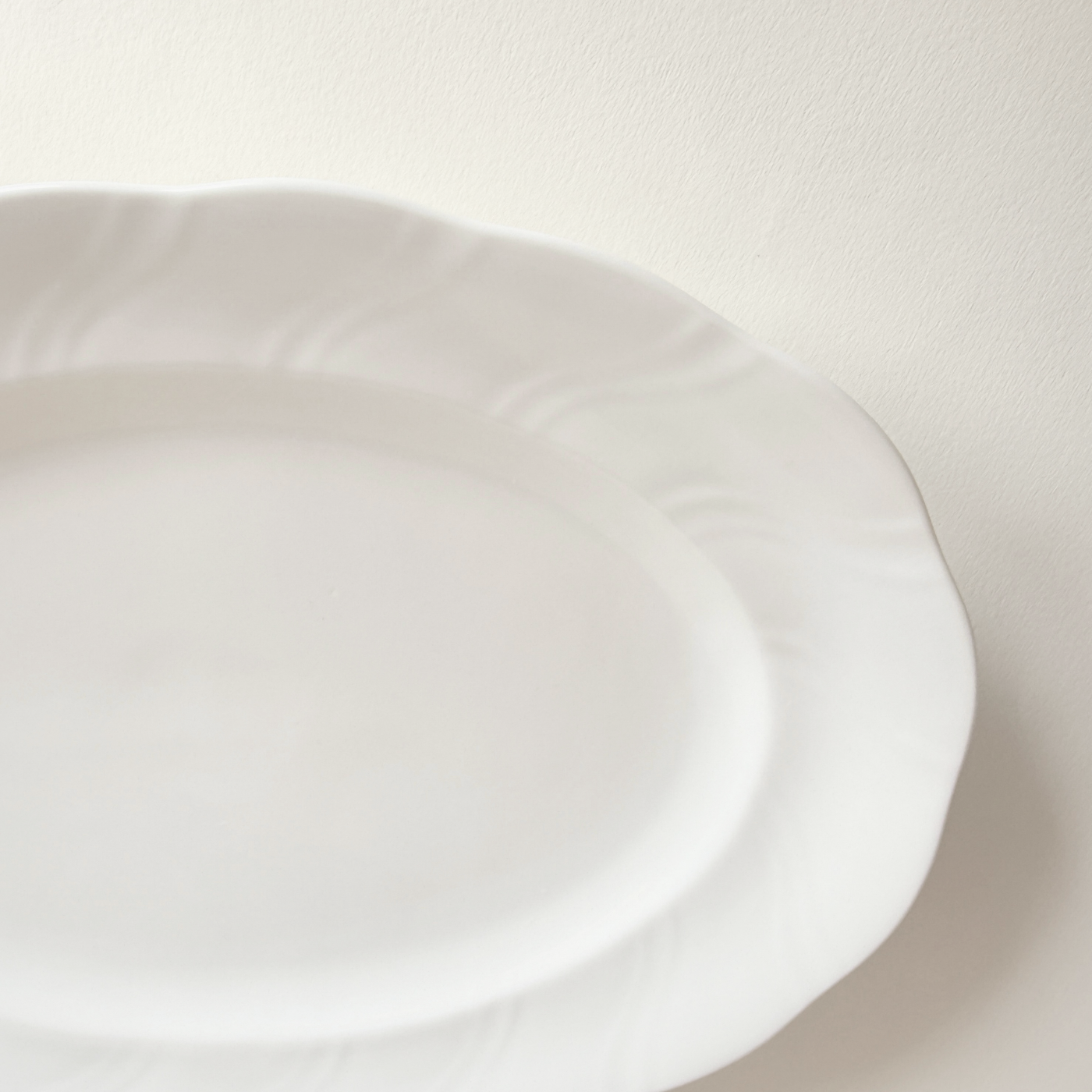 Base of white oval porcelain serving dish — unglazed foot ring, clean underside, no marks