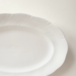 Base of white oval porcelain serving dish — unglazed foot ring, clean underside, no marks